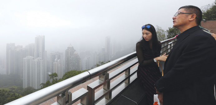 Mainland Chinese visitors look at the foggy skyline of Hong Kong island yesterday from the Peak in Hong Kong. The number of mainland Chinese visitors 