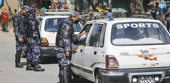 A policeman talking to a driver at a checkpoint during a city-wide strike in Kathmandu yesterday.