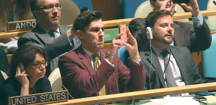 Members of the US delegation photographing the vote tally display after the UN General Assembly has passed its resolution.