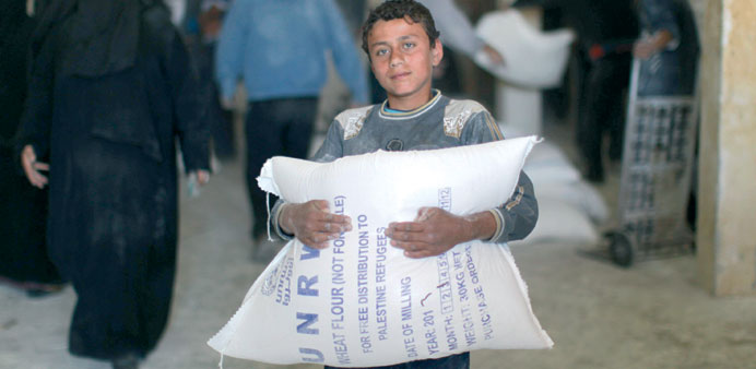 A boy carries a sack of flour at a UN Relief and Works Agency aid distribution centre in Gaza City yesterday.