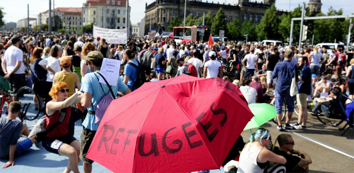 An anti-racism protesters holds an umbrella with the lettering ,Refugees Welcome, during a rally in Dresden