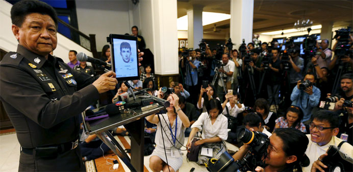 Thai police spokesman Prawut Thawornsiri shows a sketch of a suspect believed to be involved in the recent Bangkok blast 