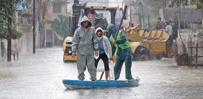 Men ride a boat through floodwaters in Al Zaitun area, east of Gaza City, yesterday.
