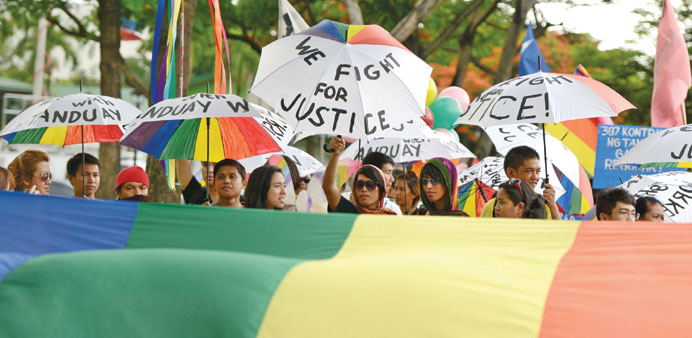 Participants hold up umbrellas painted in rainbow colours and slogans during a gay pride march in Manila yesterday.