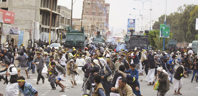 Protesters flee as riot police use teargas to disperse them along a main road leading to the airport in Sanaa yesterday.  