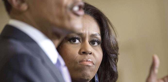 In this March 3, 2015 file photo, US first lady Michelle Obama listens while her husband US President Barack Obama speaks during an event in the East 