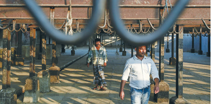 Workers walk through a shed past empty meat hooks during a strike against a ban on the slaughter of bulls and bullocks at an abattoir in Mumbai yester