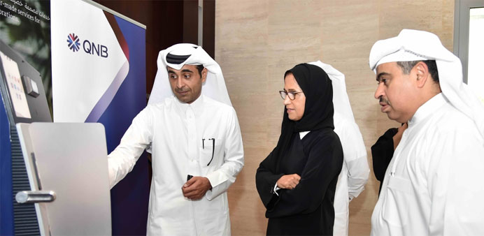  tHE al-Jaber along with al-Kuwari (right) viewing iris recognition technology, to be deployed at QNB branches and ATMs.