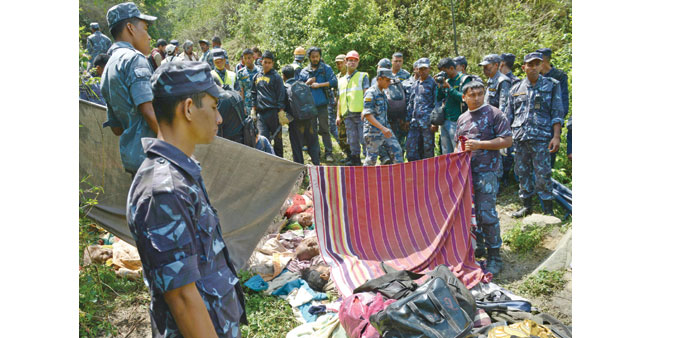 Rescue workers gather around the bodies of Indian pilgrims at the site of a bus accident in Jhyaprekhola in Dhading district, some 25km from the capit