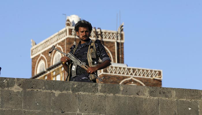 A Houthi militant stands guard on a bridge in Sanaa.