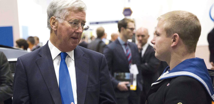 Secretary of Defence Michael Fallon speaks with a member of the Royal Navy at the Defence and Security Equipment International trade show in London ye