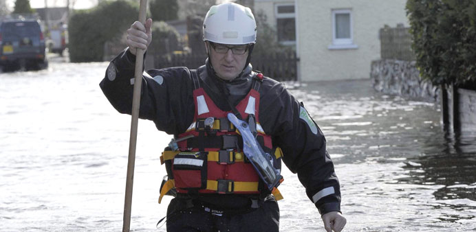 A member of the emergency services wades through the floods in the village of Moorland on the Somerset Levels in south west England yesterday.