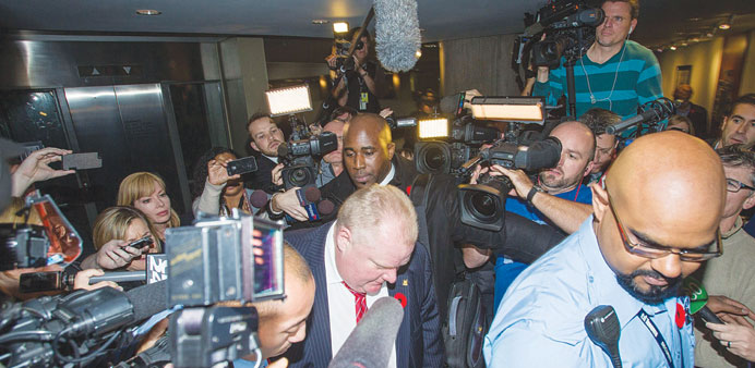 Ford arrives to a crush of media at his office at Toronto City Hall yesterday.