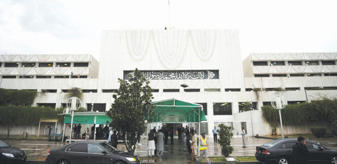 Pakistani security personnel and other officials gather outside the Parliament House building during the last session of the parliament in Islamabad y