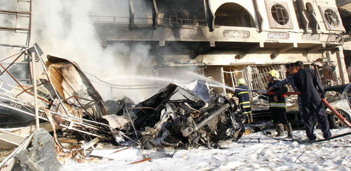 Firefighters spray water at the scene of a car bomb attack in Kirkuk yesterday.