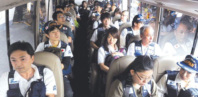 Members of the Japan Disaster Relief Team ride onboard a bus as they arrive at Manilau2019s International Airport yesterday. The group is flying to Taclob