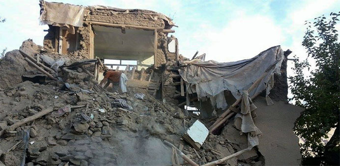 An Afghan man digs through the rubble of a damaged building after a powerful earthquake in Ramankheel 