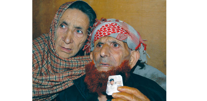 Parents of convicted killer Shafqat Hussain, displaying a photograph of their son, in Muzaffarabad.