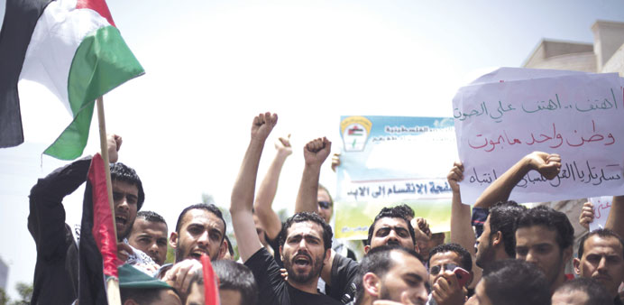    Protesters chant slogans urging speedy implementation of the unity deal during a rally in Gaza City yesterday.