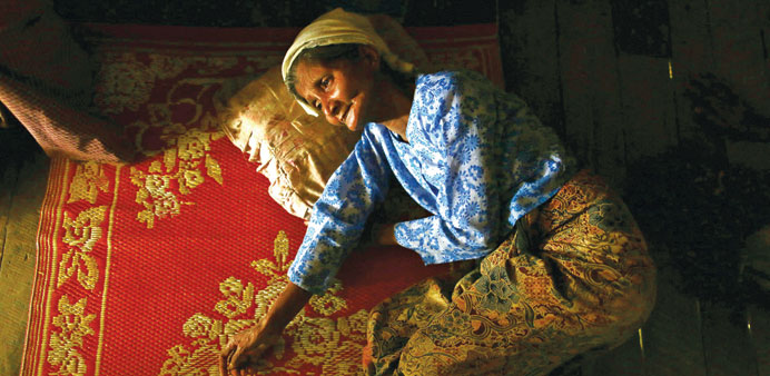 Zawrina Hattu, 52, lies on her bed in a village at Maungdaw in June. Hattu has been stricken with illness for a month.