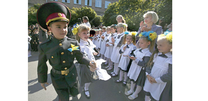 Boys and girls from cadetu2019s lyceum ring in a bell as they run around a school yard at the first day of school in Kiev.
