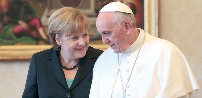 Pope Francis speaks with Merkel during a private audience at the Vatican, yesterday.