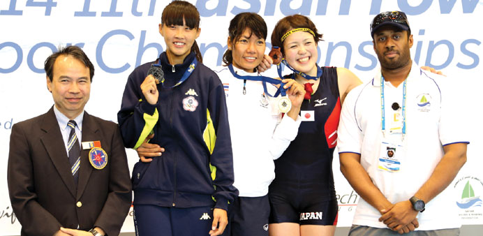 Winners of the Asian Indoor Rowing Championship celebrate at the podium.