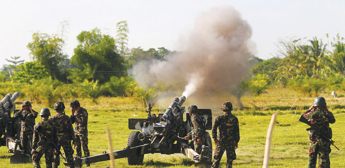 Government forces of the sixth Infantry Division fire a Howitzer cannon in Maguindanao, southern Philippines. 