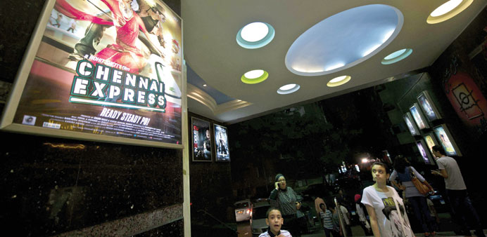 Egyptians walk past a poster for Bollywood film Chennai Express in the Galaxy cinema in Cairo.