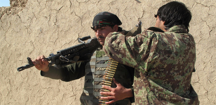 Afghan National Army (ANA) soldiers adjust their equipment in Helmand 
