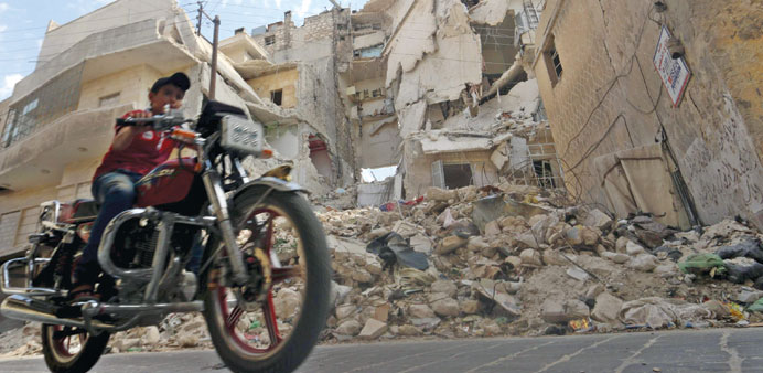 A boy rides a motorcycle through a street in Old Aleppo yesterday.