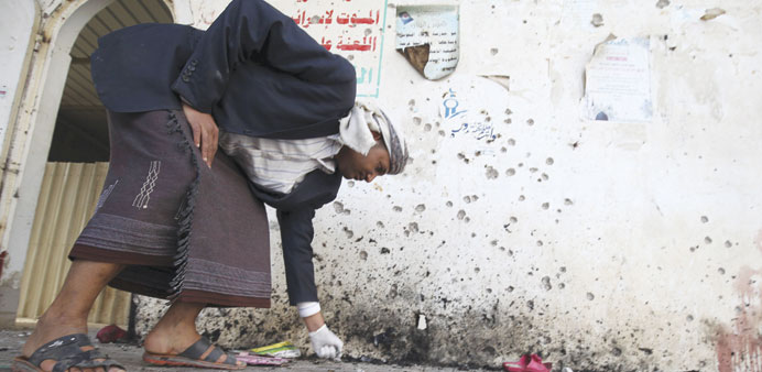 A crime scene investigator looks at the ground after a suicide bomb attack at a mosque in Sanaa yesterday.