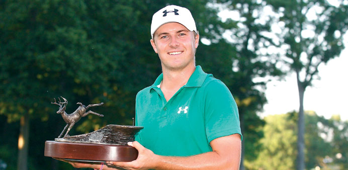Jordan Spieth holds the trophy after winning a three way five hole sudden death playoff after the final round of the John Deere Classic held at TPC De