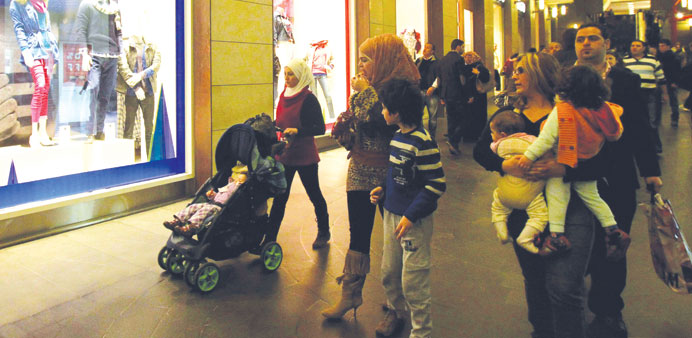 Lebanese walk past a shop window in the capitalu2019s Beirut Souks shopping district on Sunday.