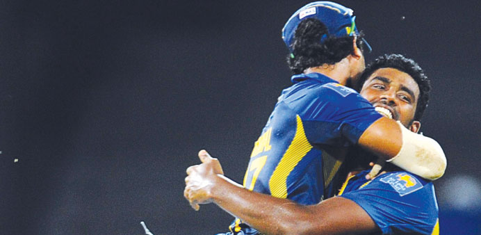 Sri Lankan cricketer Thisara Perera (R) celebrates with teammates the dismissal of South African batsman Jean-Paul Duminy during the second ODI at the