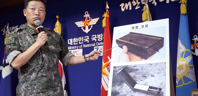 A South Korean military officer shows pictures of North Korean u2018wooden boxu2019 landmines during a briefing at the defence ministry.