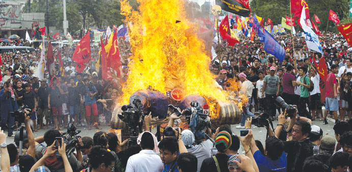 Anti-government protesters burn an effigy representing Philippine President Benigno Aquino during a protest in Manila yesterday, to coincide with Aqui