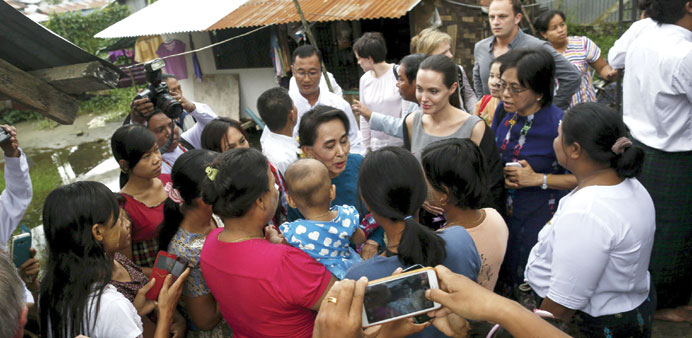 Myanmar pro-democracy leader Aung San Suu Kyi and UNHCR special envoy Angelina Jolie Pitt meet with female factory workers at their hostel in the Hlai